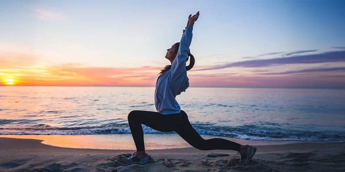 Aktywna kobieta na plaży o zmierzchu - energia i relaks dzięki Magnezowi MSE